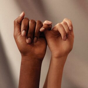 two hands with linked pinky fingers