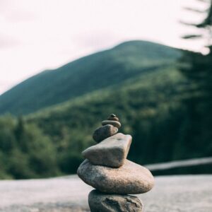 Carefully balanced rock cairn against a serene mountain backdrop