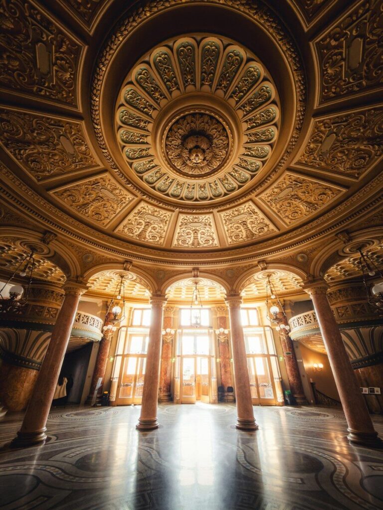 Ornate domed ceiling and marble columns in the Caru cu Bere in Bucharest