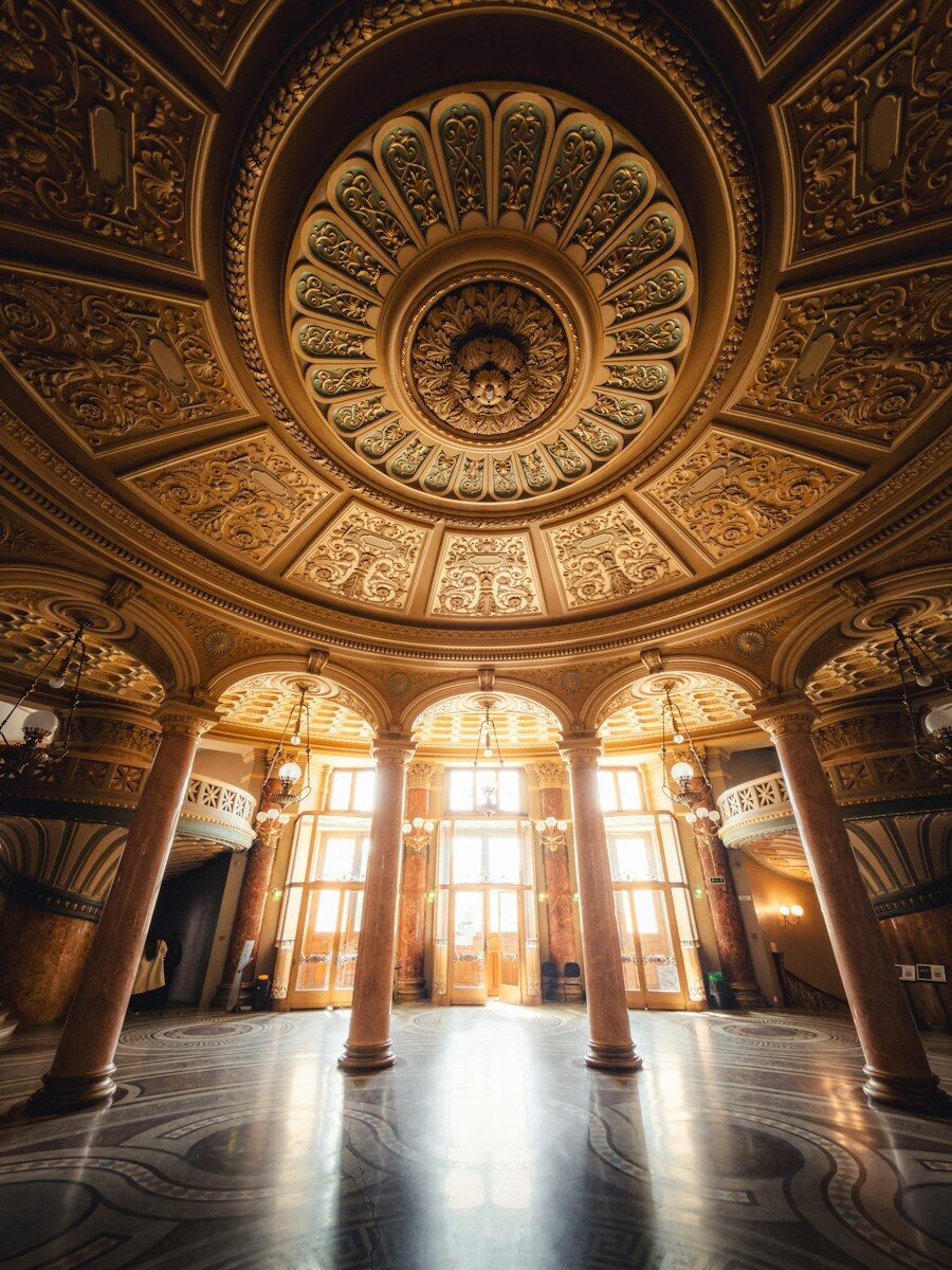 Ornate domed ceiling and marble columns in the Caru cu Bere in Bucharest